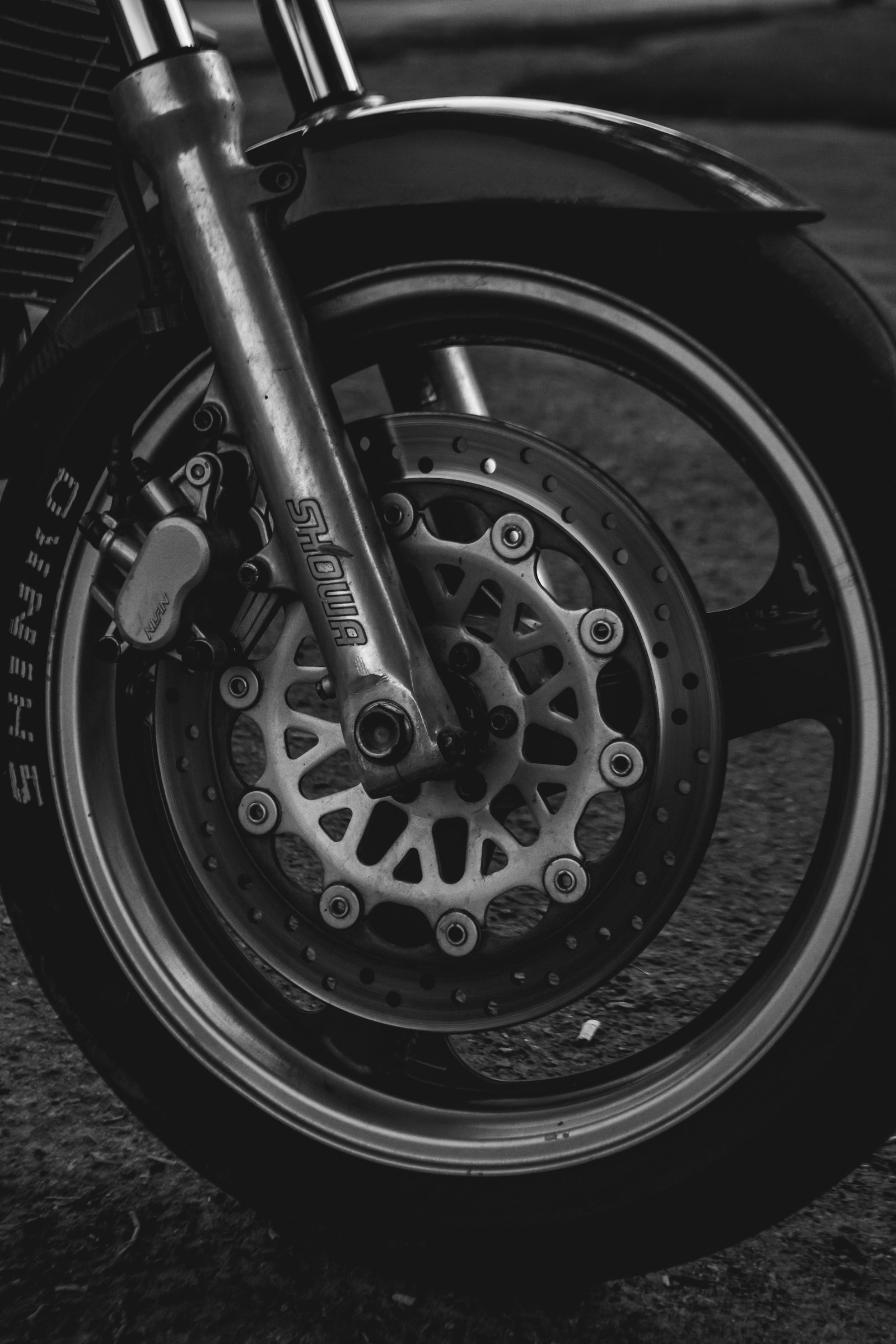 Rueda delantera y neumático de una moto junto al disco de freno