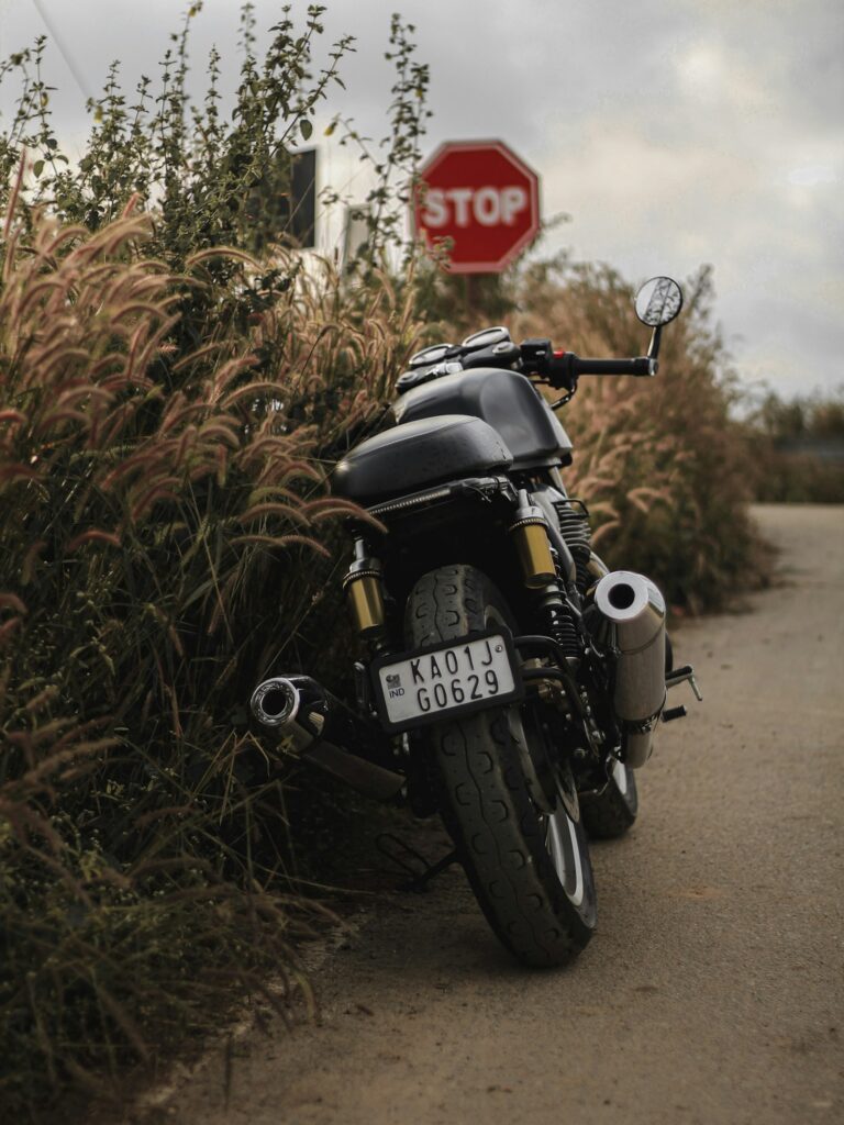 Café racer negra aparcada junto a una carretera rural
